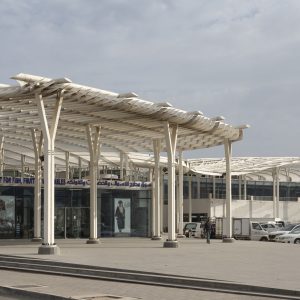 The new market celebrates the continuity of the region’s trade and fishing traditions, while also catering to Oman’s growing tourism industry.  Muttrah’s top tourist attraction, it houses a rooftop restaurant in addition to the market itself.  The design exemplifies contextual regionalism, respecting the scale and integrity of the traditional context whilst adding new and dynamic elements.  The curved wall that defines its spine reflects the radial shape of the corniche and bay area, and has light-filtering pierced decoration.  The canopy’s form is inspired by the sinuous flow of Arabic calligraphy and exploits the play of light and shadow. Its aluminium fins provide shade, natural ventilation and an ephemeral appearance that contrasts with the simple solidity of the concrete structure below.